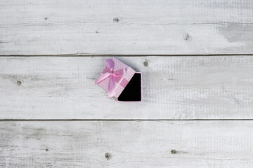Open pink gift on wooden table