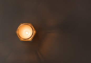 Burning candle on the table with glow of light. view from above