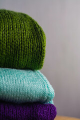 Cozy knitted sweaters of different colors are stacked on top of each other
