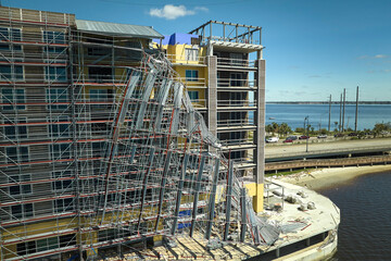 Aerial view of ruined by hurricane Ian construction scaffolding on high apartment building site in...