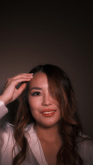 Obraz premium Girl straightens her hair and looks at the camera