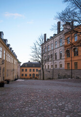Fototapeta na wymiar Alley with old 1800s court houses a winter day with low sun in Stockholm