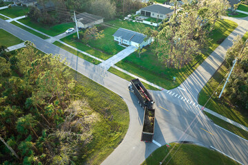 Special aftermath recovery dump truck picking up vegetation debris from suburban streets after hurricane Ian swept through Florida. Dealing with consequences of natural disaster © bilanol