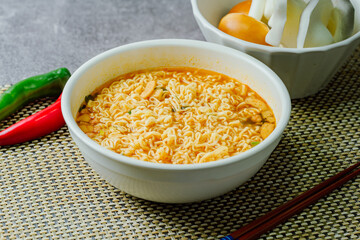 Korean instant spicy ramen dish in white bowl on table