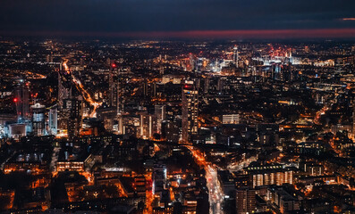 Fototapeta premium Aerial view of south west London, blue hour just after sunset, orange yellow street lights starting to glow