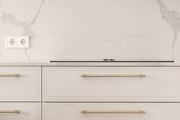 Warm white kitchen interior design, electric hob with integrated extraction. Modern kitchen interior concept