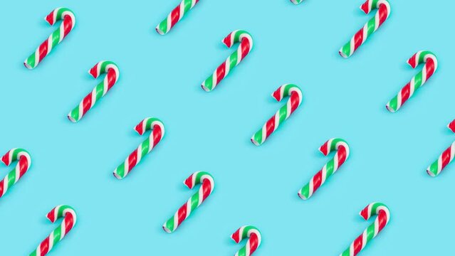 Loopable video of traditional candy canes on pastel blue background 4k.