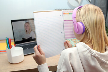 Homeschool young girl student learning virtual online class from school teacher by remote meeting.