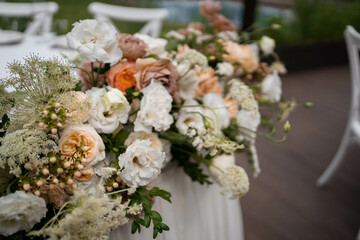 Obraz na płótnie Canvas Main table at a wedding reception with beautiful fresh flowers. Outside wedding decorations.