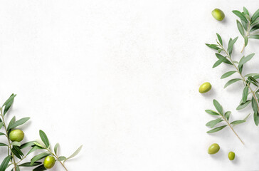 Olives and olive branches on white textured background. Background with olive leaves for your package and design.