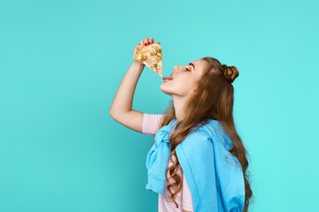 woman eating pizza slice and looking delighted
