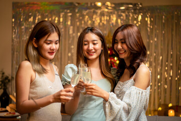 Young beautiful people smiling and clinking glass of champagne to toasting with happiness while celebrating