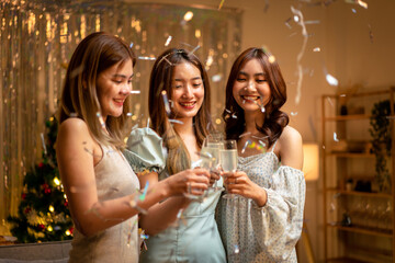 Young beautiful people smiling and clinking glass of champagne to toasting with happiness while celebrating
