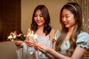 Young beautiful people holding sparkler lights firework with enjoying in night while dinner to celebrating