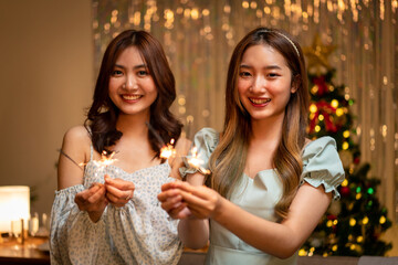 Young beautiful people holding sparkler lights firework with enjoying in night while dinner to celebrating