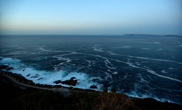 The Ocean With Foam From The Storm And The Lantern-lit Shore After Sunset