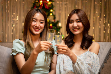 Young beautiful people is sitting on the couch to clinking glass of champagne to toasting with happiness