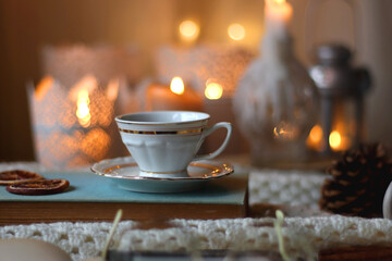 Cup of tea, books, tablet, bowl of cookies, various spices, pine cones and lit candles. Hygge at...