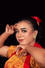 Fototapeta na wymiar a Sharp gaze from an Indonesian woman with makeup on her face while wearing an orange dress and golden earrings