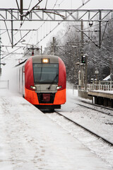 Red train rushing in the snow
