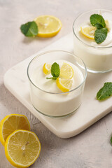 Creamy dairy yoghurt dessert sweet mousse with mascarpone, cream cheese, mint and lemon juice in...