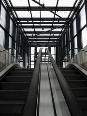 A pair of escalators with glass railing from underground floor to exit stock photo for vertical story
