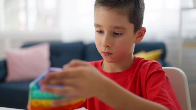 Boy playing with colorful stress relief pop it toy, helping with anxiety