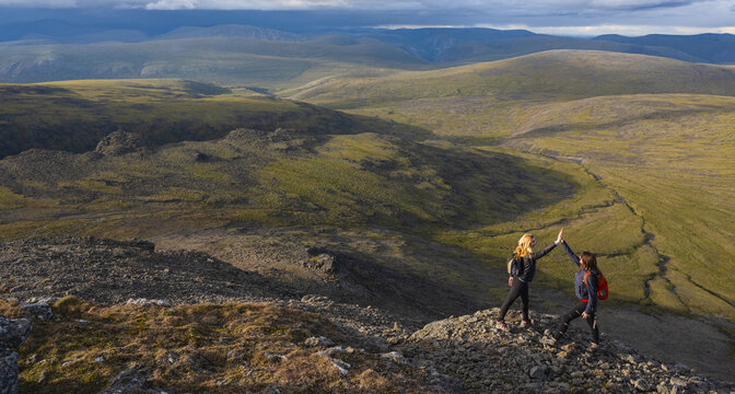Two women exploring the mountains and wilderness of the Yukon. Feeling alive and vibrant in the beautiful scenery around Haines Junction; Yukon, Canada