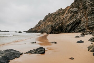 Fototapeta na wymiar Beach with rocks in cloudy weather.
