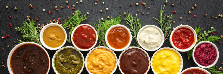 Different types of sauces in bowls with seasonings banner, rosemary and dill, thyme and and peppercorns, top view