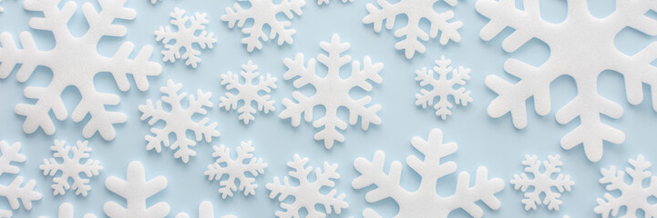 White snowflakes on a blue background, Christmas banner, Merry Christmas and Happy New Year concept, top view