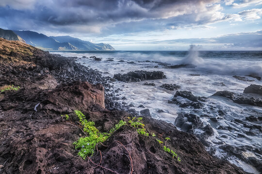 Waves hitting the Western shoreline of Oahu, Hawaii with the mountains in the distance; Oahu, Hawaii, United States of America