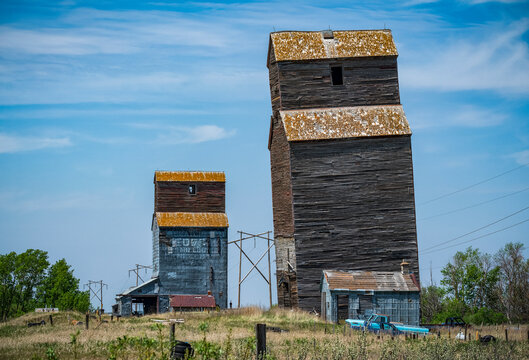 Two weathered grain elevators on the prairies; Val Marie, Saskatchewan, Canada