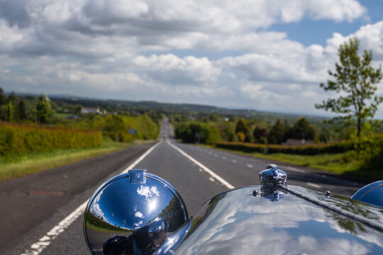 View Along The Hood Of A Vintage Car Showing Open Road Stretching Into The Distance