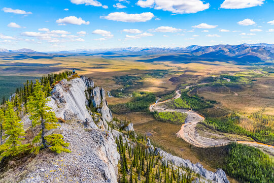 Woman hiking along the Dempster Highway enjoying the scenery on top of Sapper Hill; Yukon, Canada
