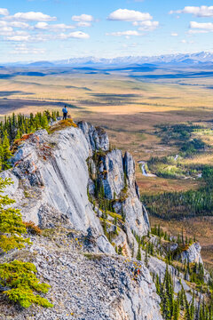 Woman hiking along the Dempster Highway enjoying the scenery on top of Sapper Hill; Yukon, Canada