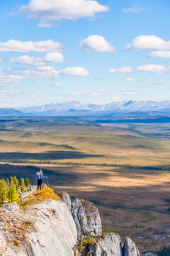 Woman hiking along the Dempster Highway enjoying the scenery on top of Sapper Hill; Yukon, Canada