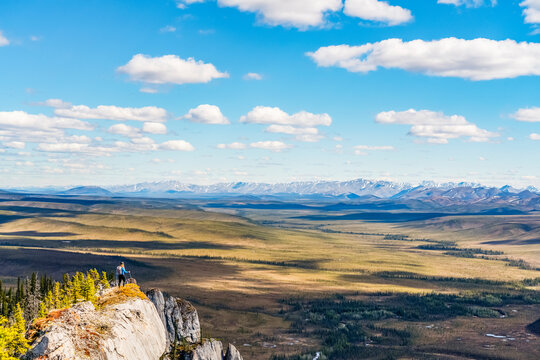 Woman hiking along the Dempster Highway enjoying the scenery on top of Sapper Hill; Yukon, Canada