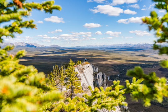 Woman hiking along the Dempster Highway enjoying the scenery on top of Sapper Hill; Yukon, Canada