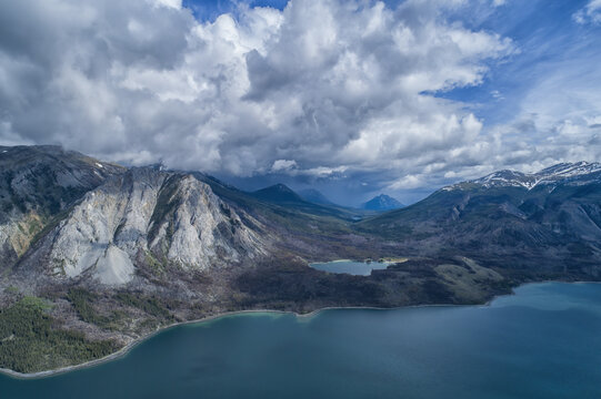 Aerial view of the lakes and dramatic Yukon mountain ranges under a stormy sky; Carcross, Yukon, Canada