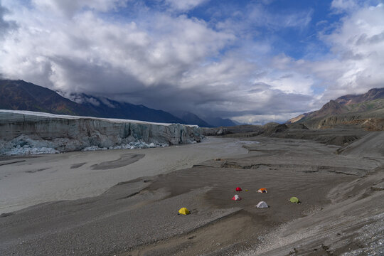 The Donjek glacier in Kluane National Park. A group of hikers has set up a basecamp in front of the glacier.