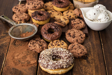 A sweet table containing ice cream, donuts and chocolate chip cookies