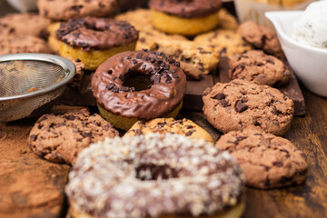 A sweet table containing ice cream, donuts and chocolate chip cookies