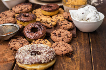 A sweet table containing ice cream, donuts and chocolate chip cookies