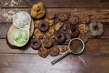 A sweet table containing ice cream, donuts and chocolate chip cookies