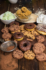 A sweet table containing ice cream, donuts and chocolate chip cookies