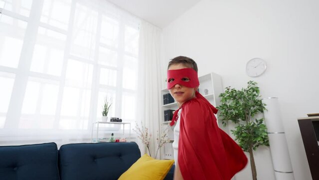 Portrait of adorable schoolboy in a superhero costume, Halloween celebration