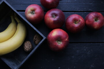 Ripe bananas and apples on an old vintage table.