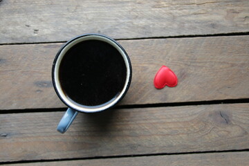 Black coffee cup on old wooden table top view.