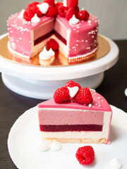 Beautiful pink cake with raspberries, sweet dessert. Home pastry chef. A piece of cake is cut off for a tea party